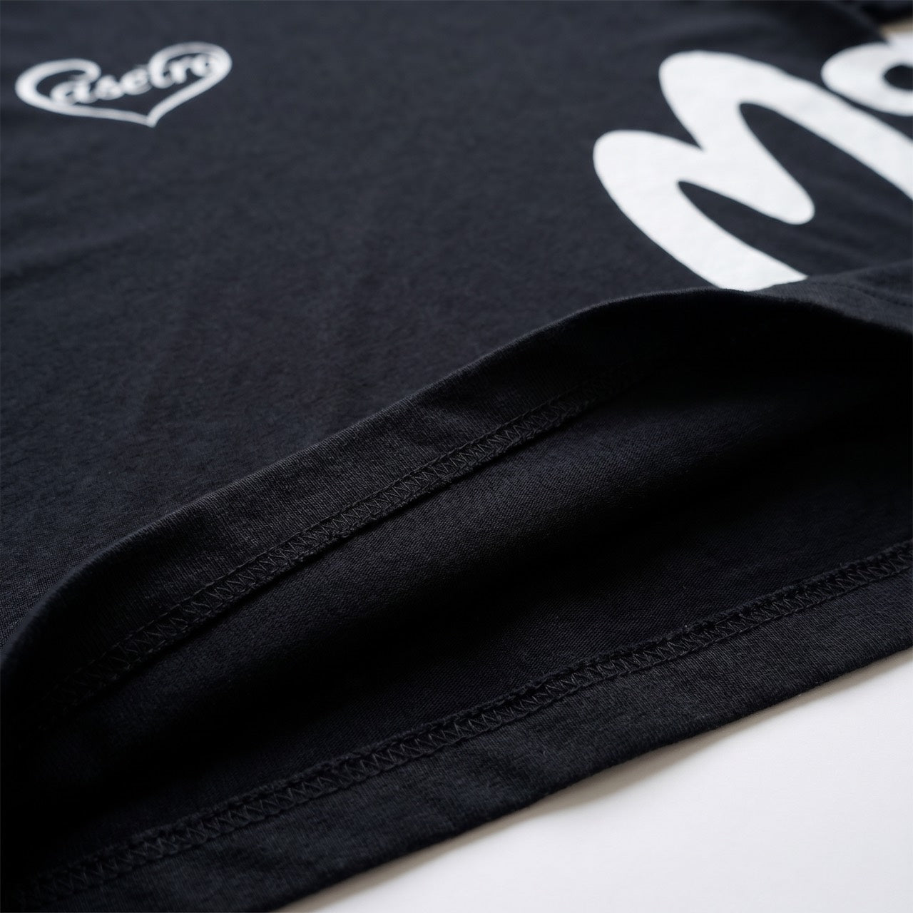 Black cotton T-shirt, close-up of hem and stitching