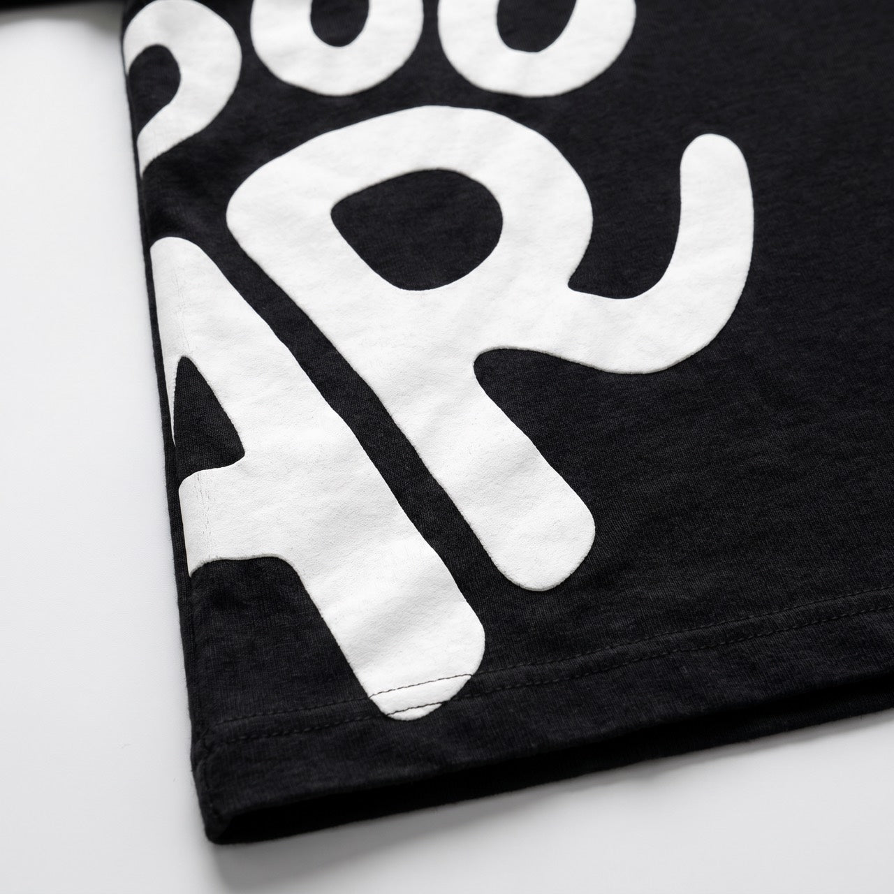 Black T-shirt with white artwork, print and hem detail