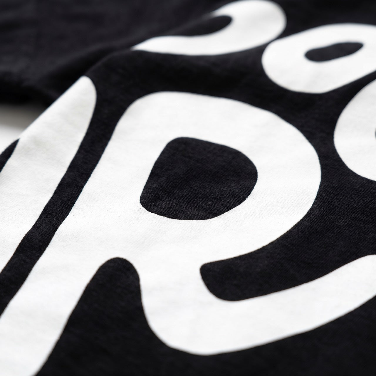 White graphic print on black cotton, texture close-up