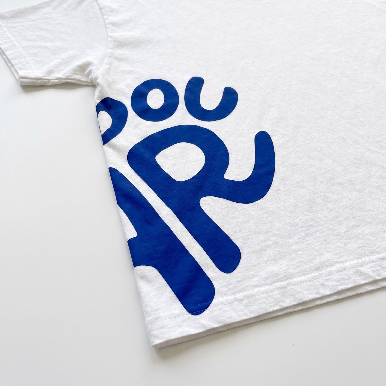 Navy artwork on white cotton, sleeve and hem detail