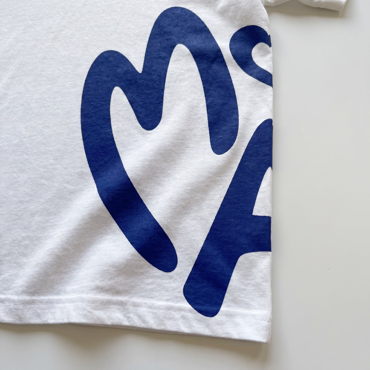 Navy graphic on white cotton, close-up of stitching